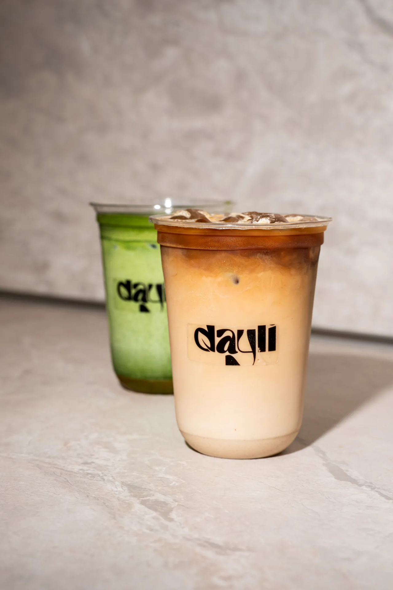 Iced Coffee und Iced Matcha im dayli-Becher nebeneinander