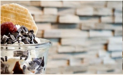 Eisbecher mit Sahne, Schokoladenstücken und Waffel